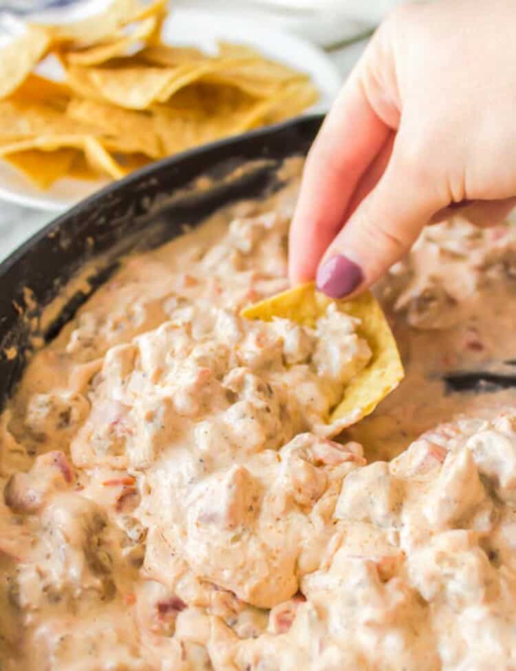 Dipping into sausage dip with a chip