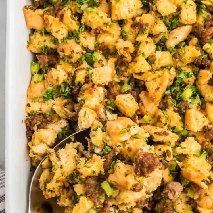 Overhead shot of sausage stuffing in a baking dish with a serving spoon