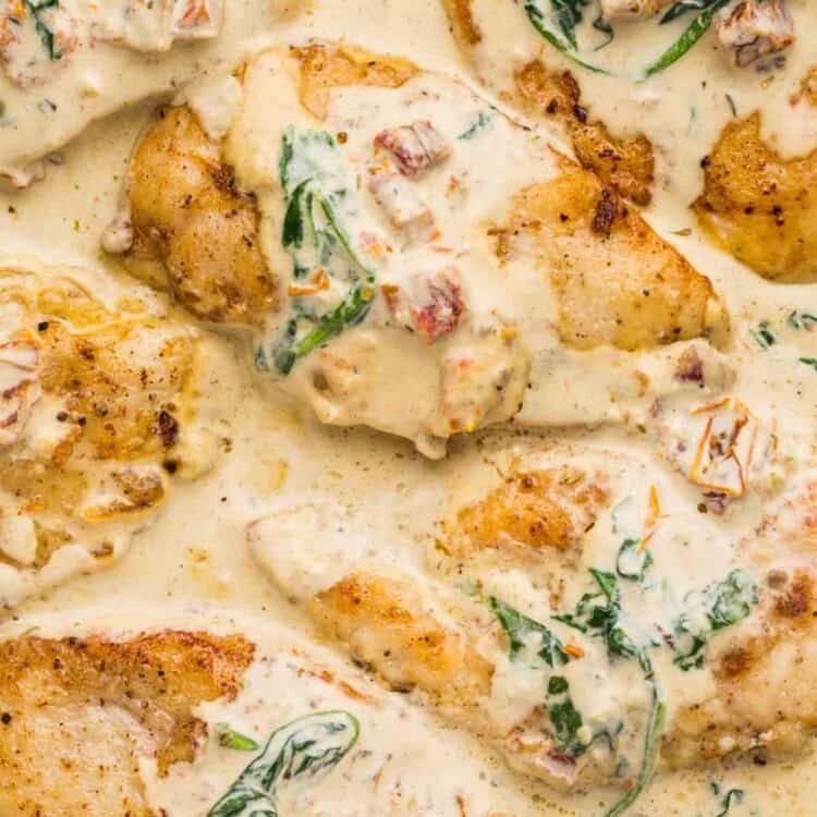 Overhead shot of Tuscan chicken in a cream sauce in a stainless steel skillet