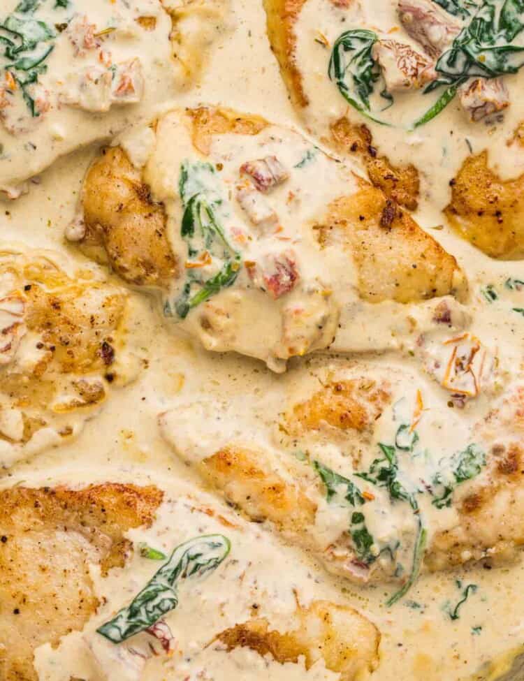 Overhead shot of Tuscan chicken in a cream sauce in a stainless steel skillet