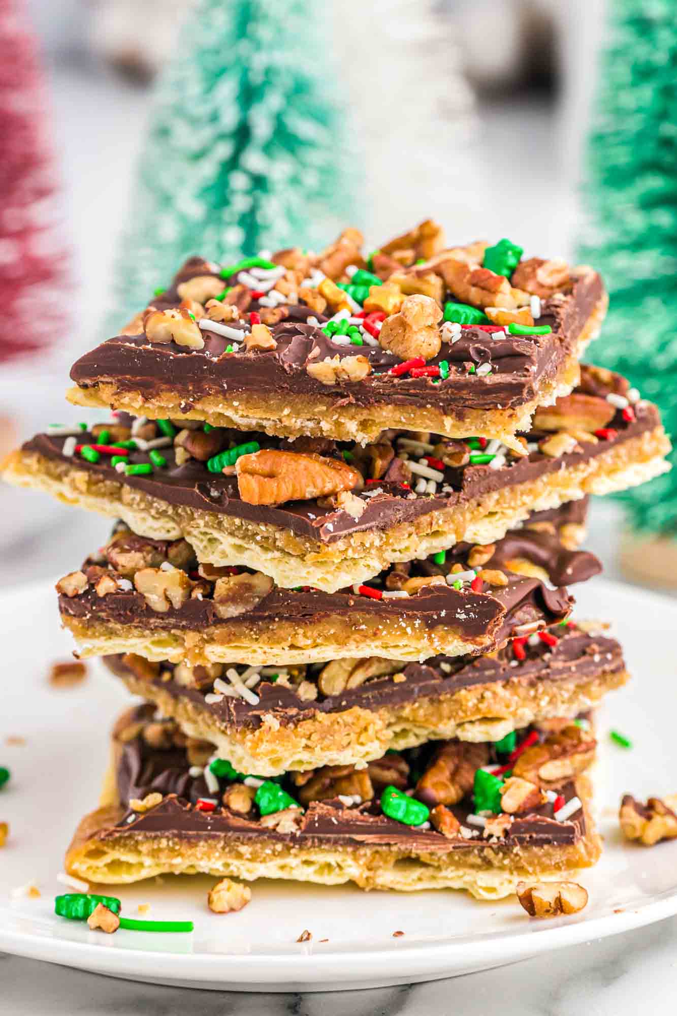 A stack of Christmas crack candy on a white plate