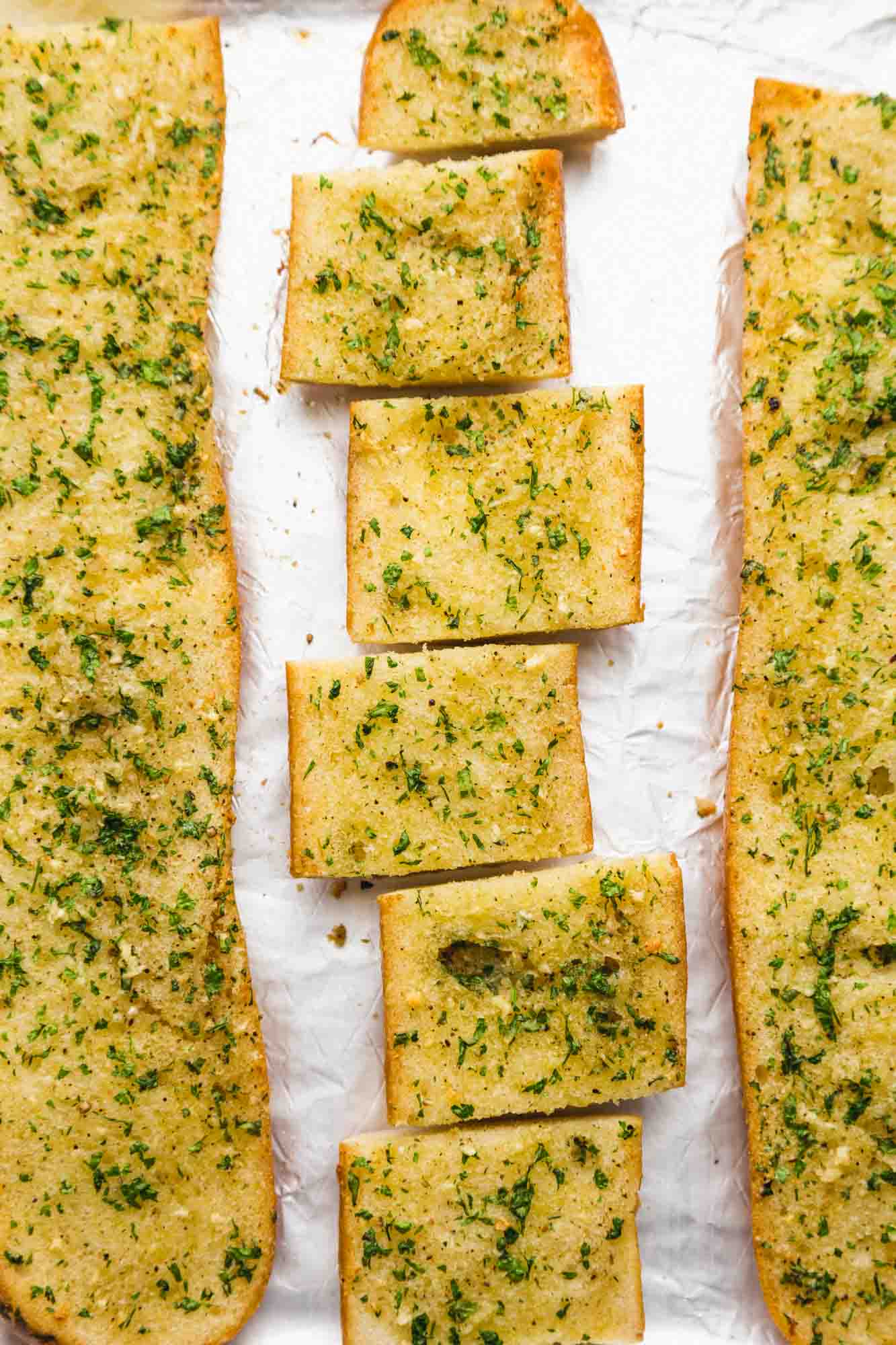 Overhead shot of garlic bread before and after slicing