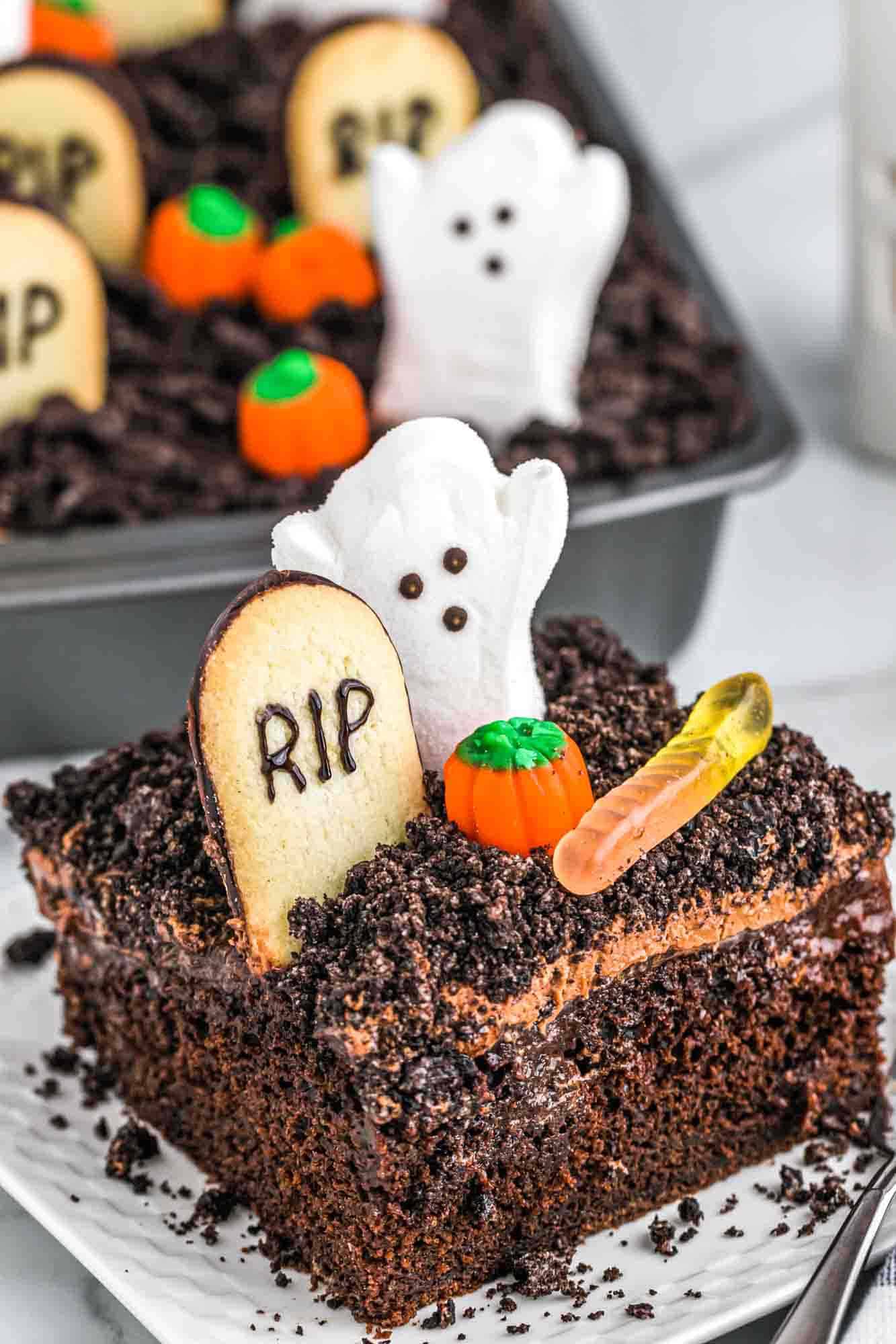 A slice of halloween dirt cake served on a square white plate