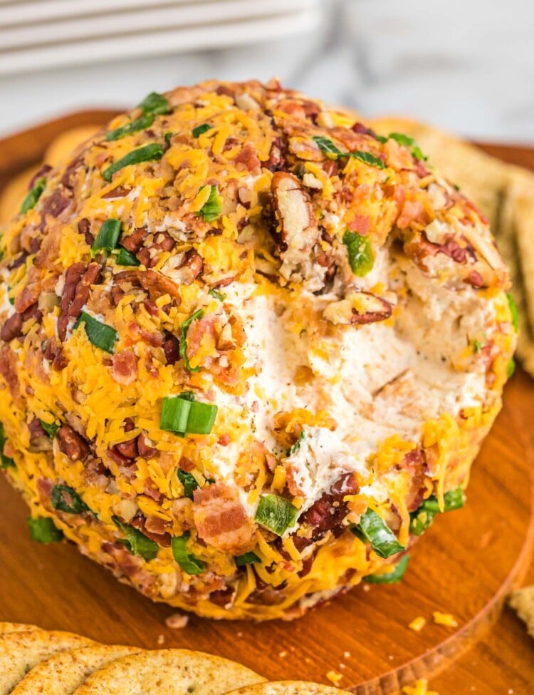 How to Make Bacon Ranch Cheese Ball served on a wooden board with crackers