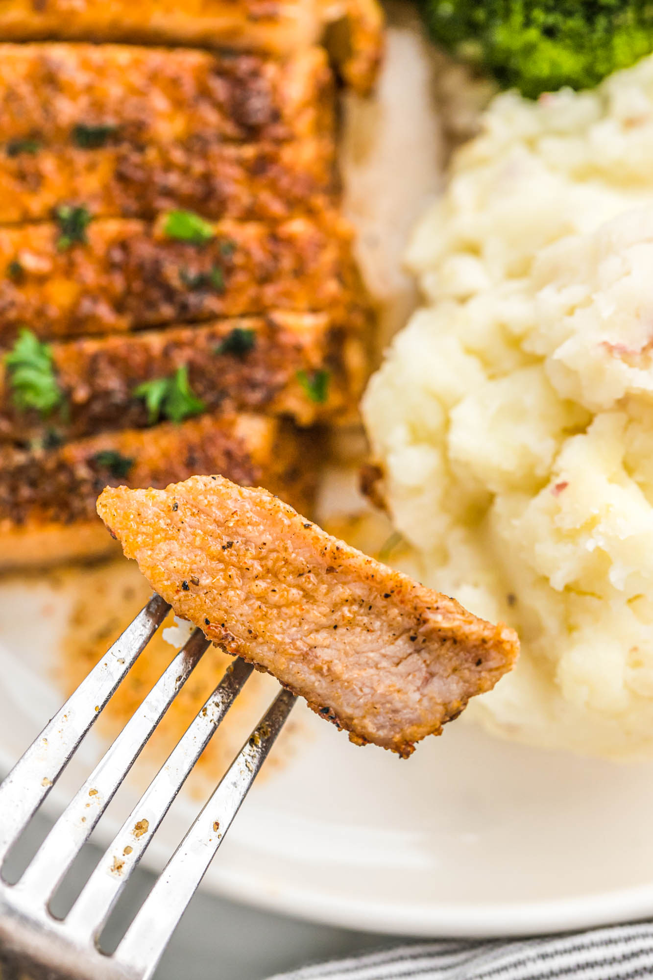 Taking a piece of baked pork chop with a fork