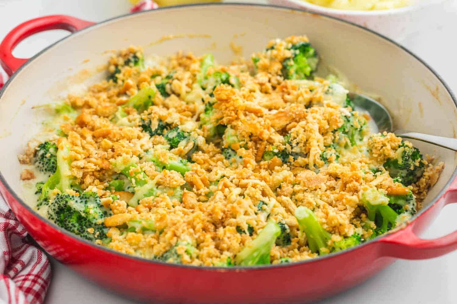 Broccoli casserole with crunchy topping in an enamelled cast iron casserole dish