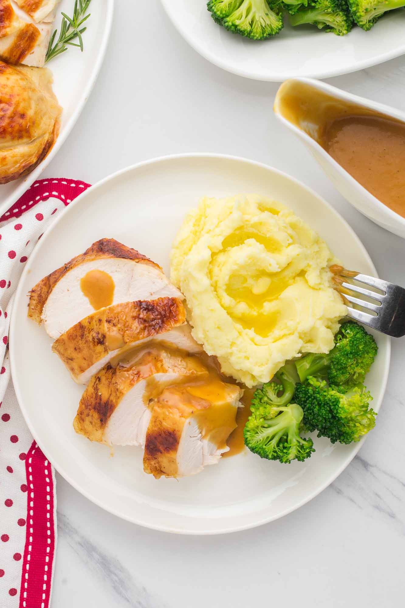 OVerhead shot of a plated chicken slices with mashed potatoes and broccoli