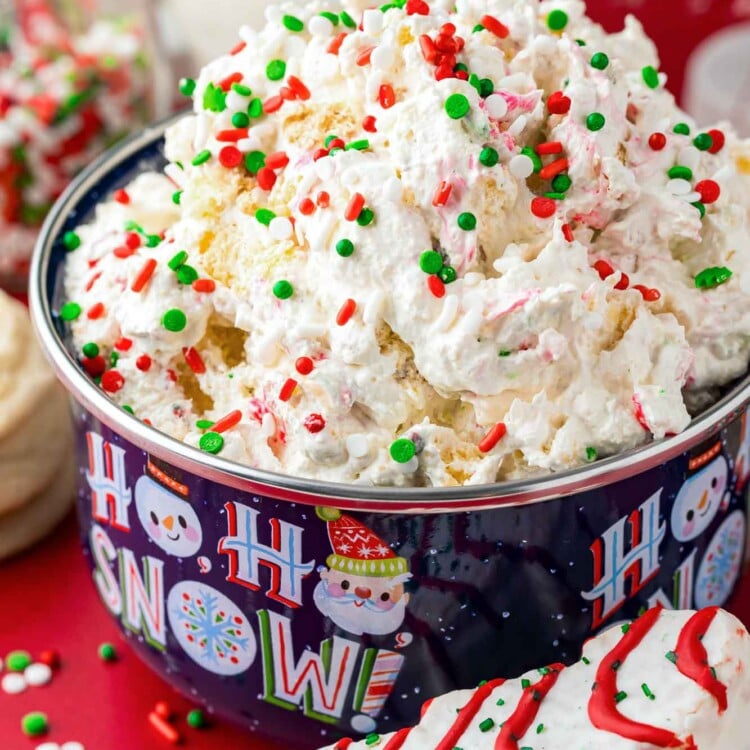 Christmas Tree Cake Dip served in a Christmas themed bowl, topped with holiday sprinkles.