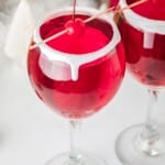 Christmas themed cocktails with maraschino cherries on a pick