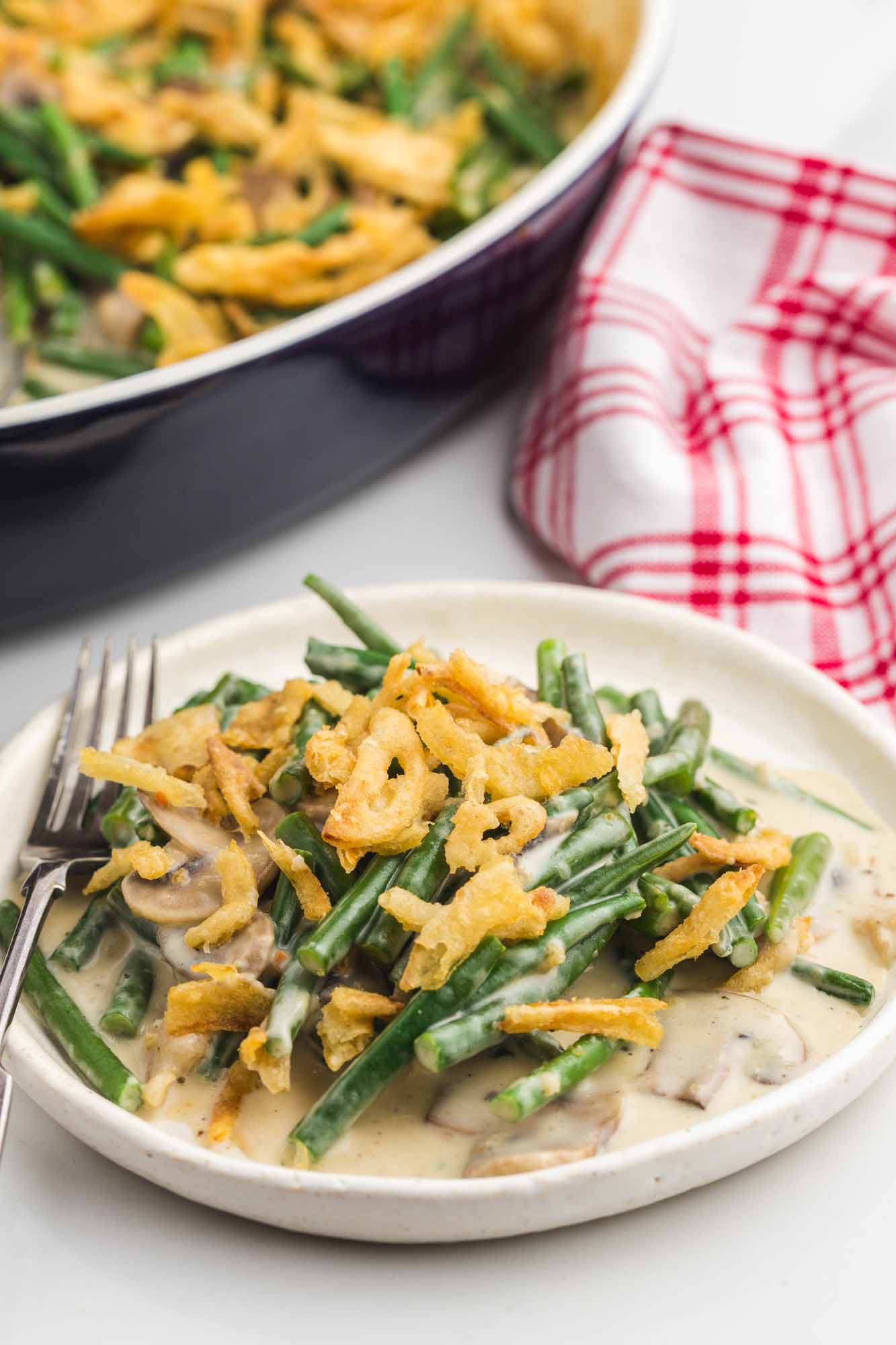 Plated green bean casserole using a white plate and a fork