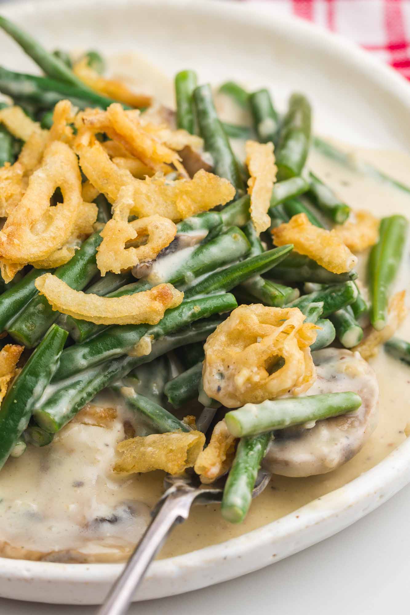 Plated green bean casserole, close up shot with a fork.