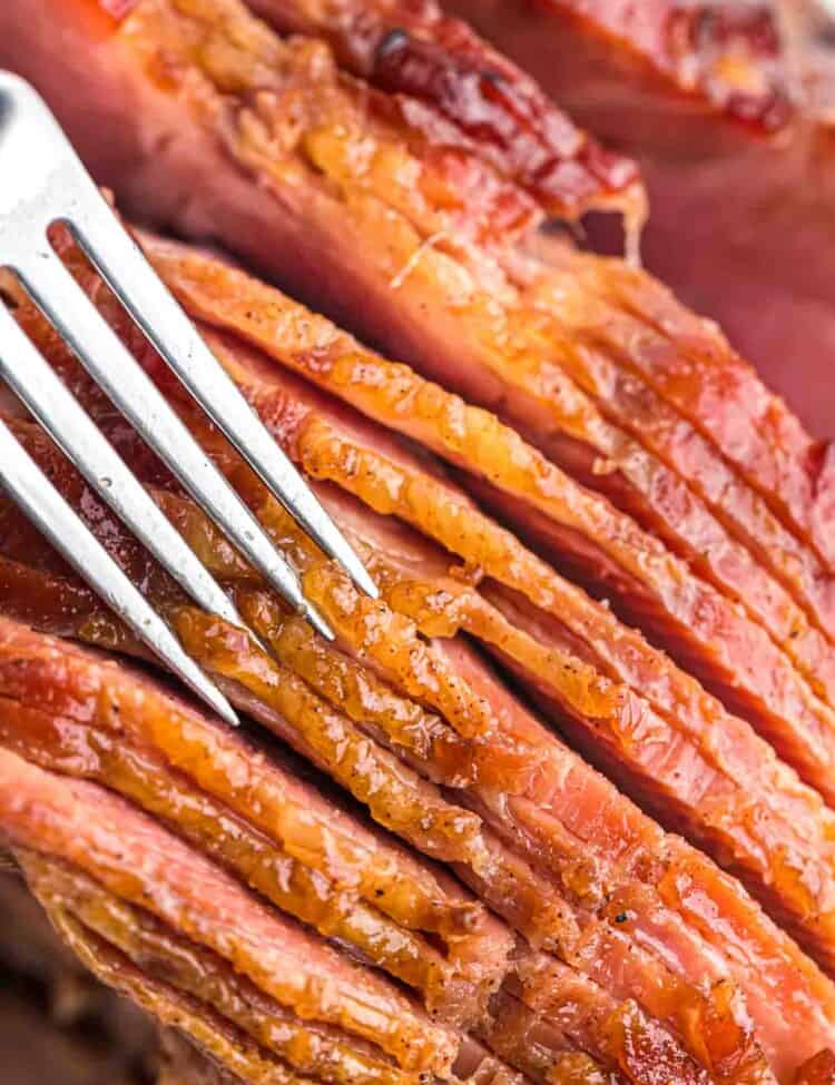 Close up shot of the crust of honey baked ham and a fork