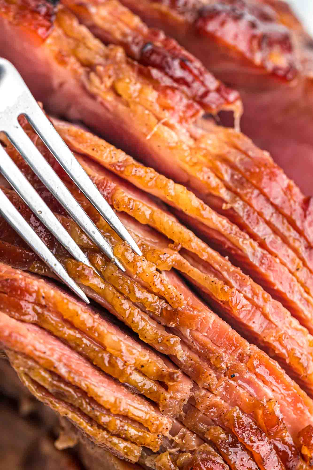 Close up shot of the crust of honey baked ham and a fork