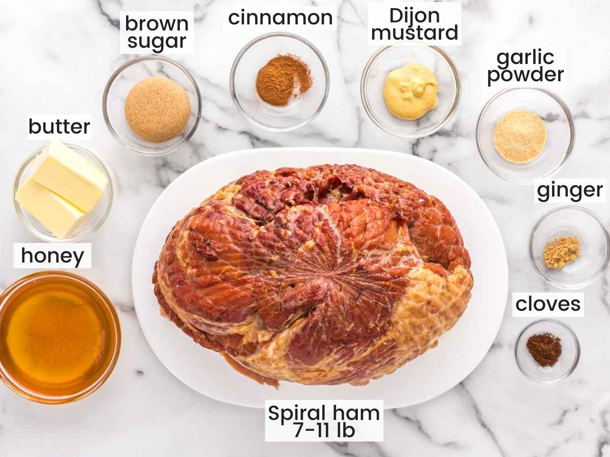 Ingredients needed for making honey baked ham including a spiral cut ham, honey, and seasonings.