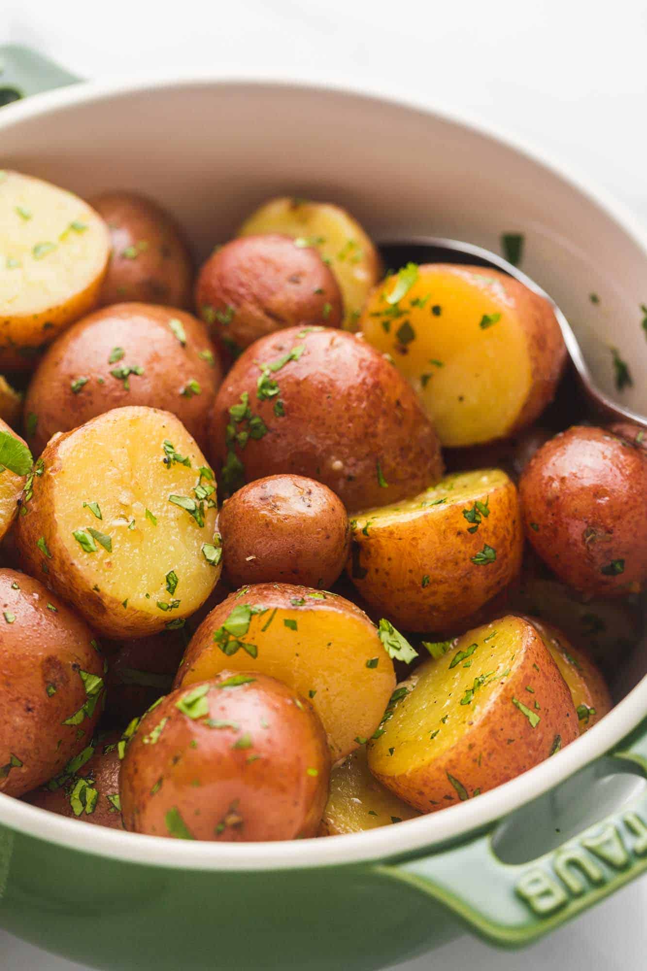 Cooked baby red potatoes in a green bowl