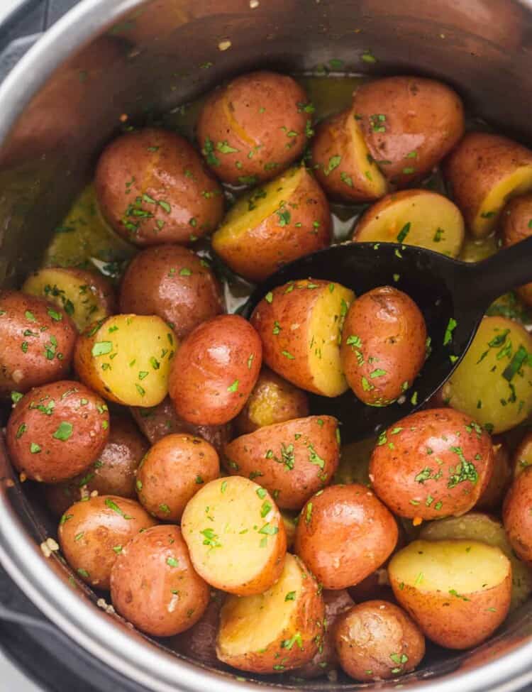 Close-up of baby red potatoes in the Instant Pot, cooked with garlic butter and herbs