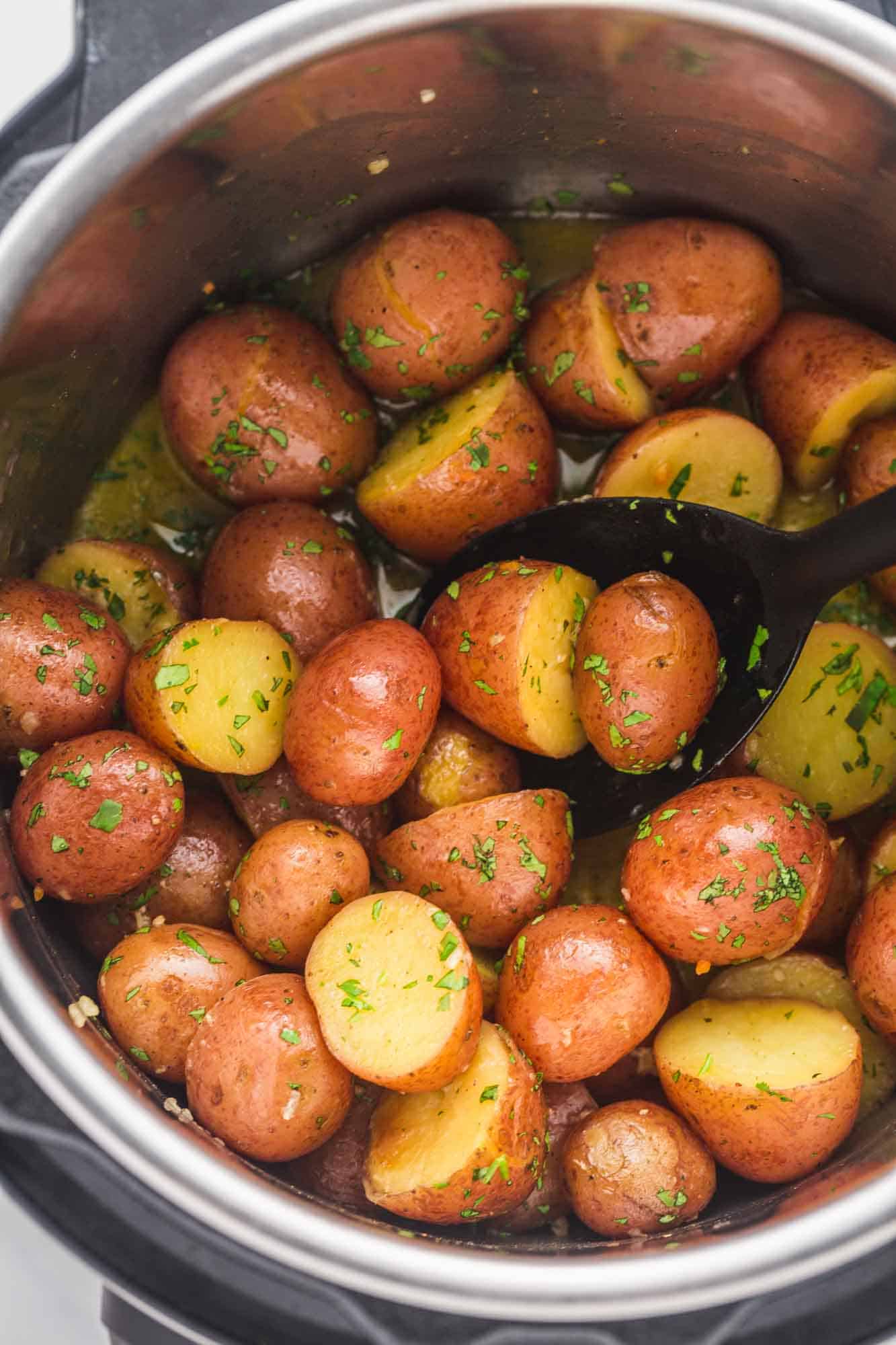 Cooked red potatoes in the instant pot with a serving spoon