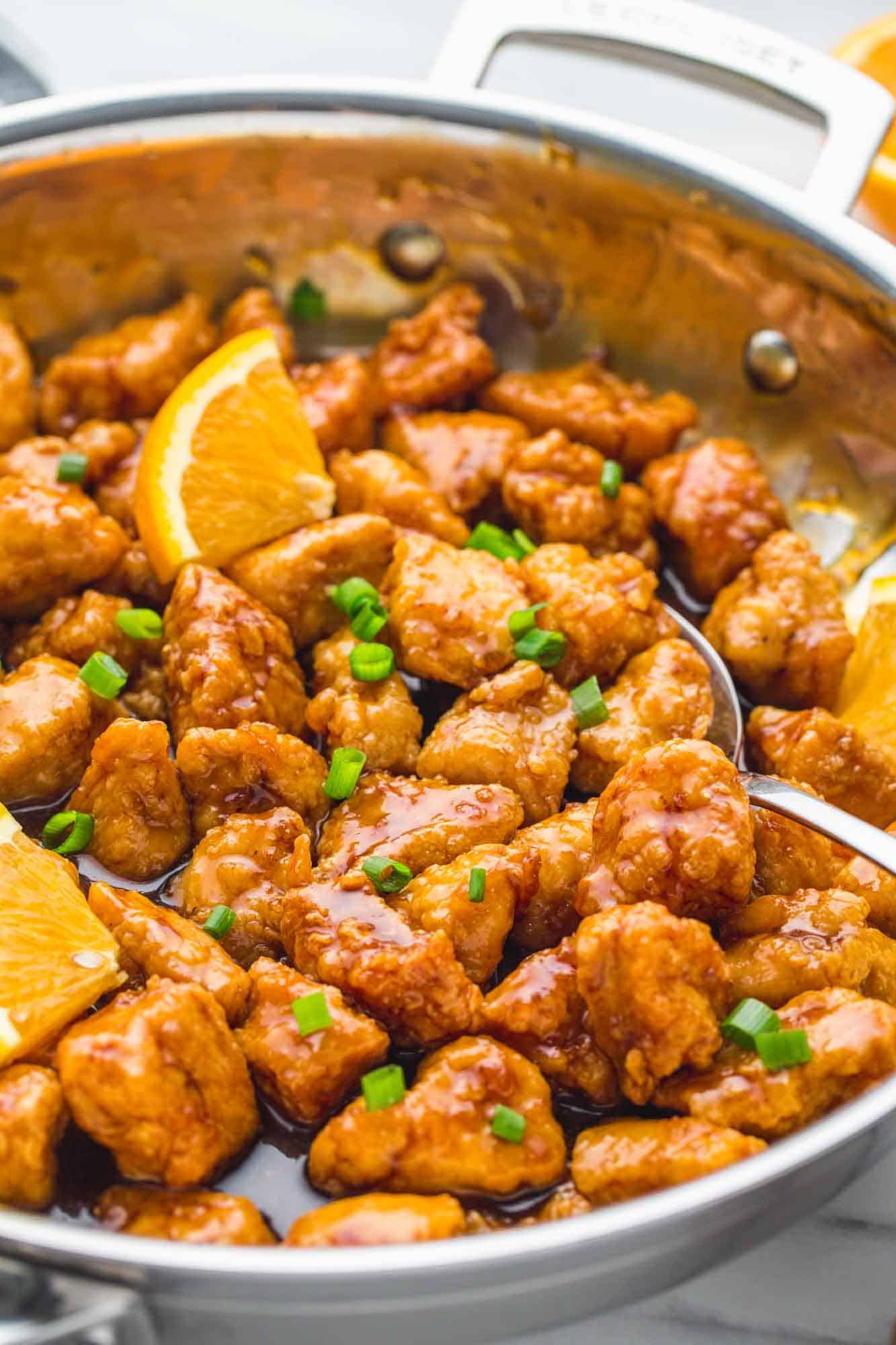 Image with an angle of orange chicken in a skillet