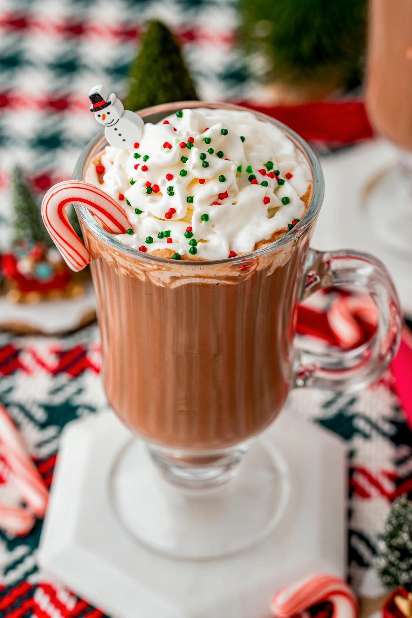 A mug of peppermint hot chocolate with whipped cream and sprinkles
