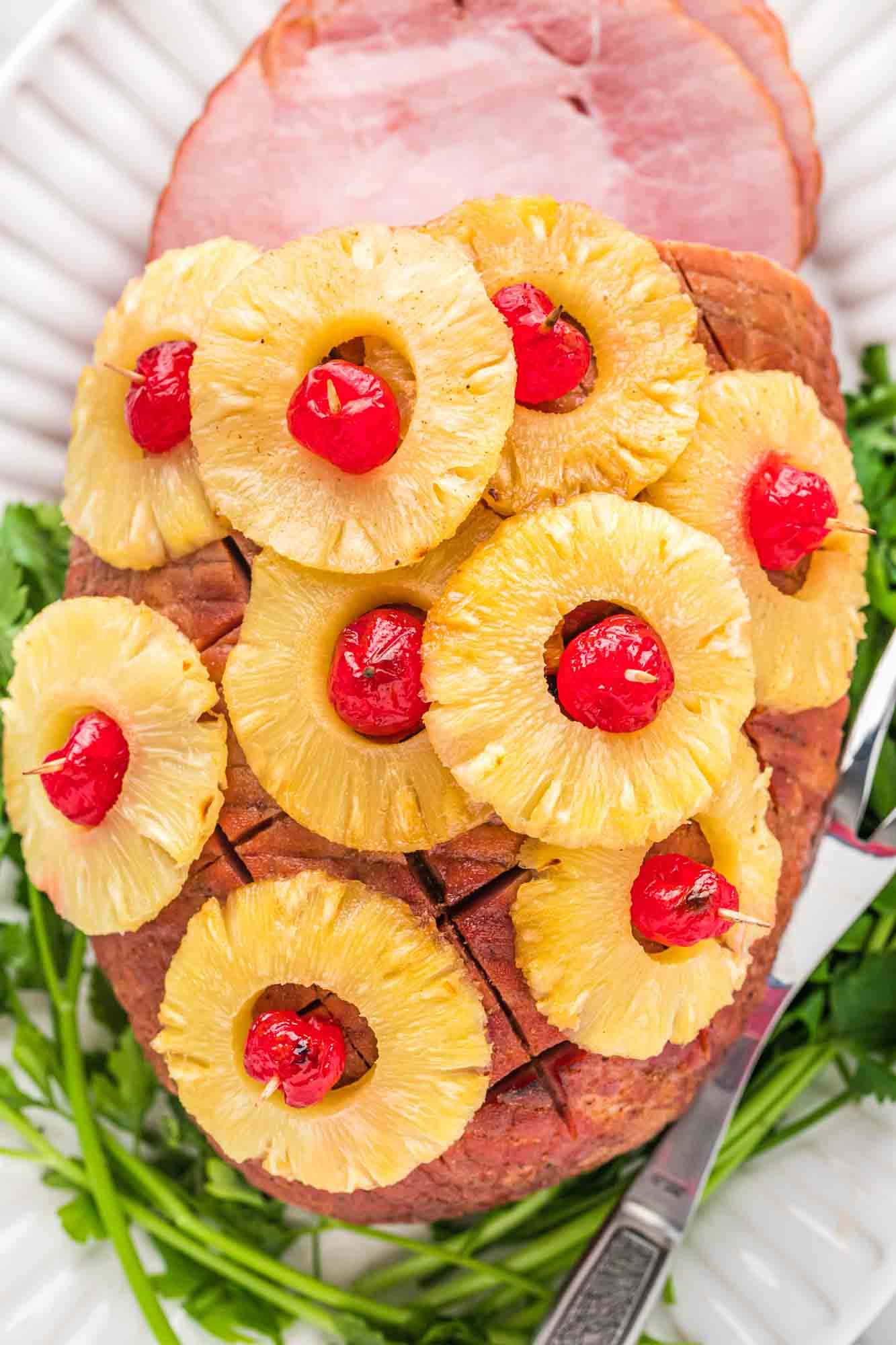 Overhead shot of pineapple ham with slices of pineapple and cherries