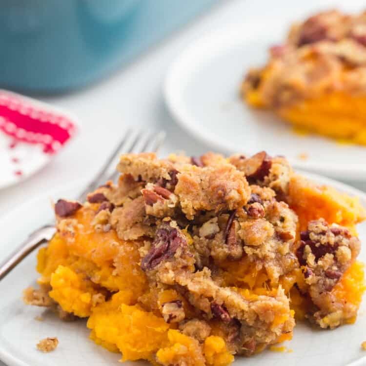 A serving of sweet potato casserole with crunchy pecans on a small plate