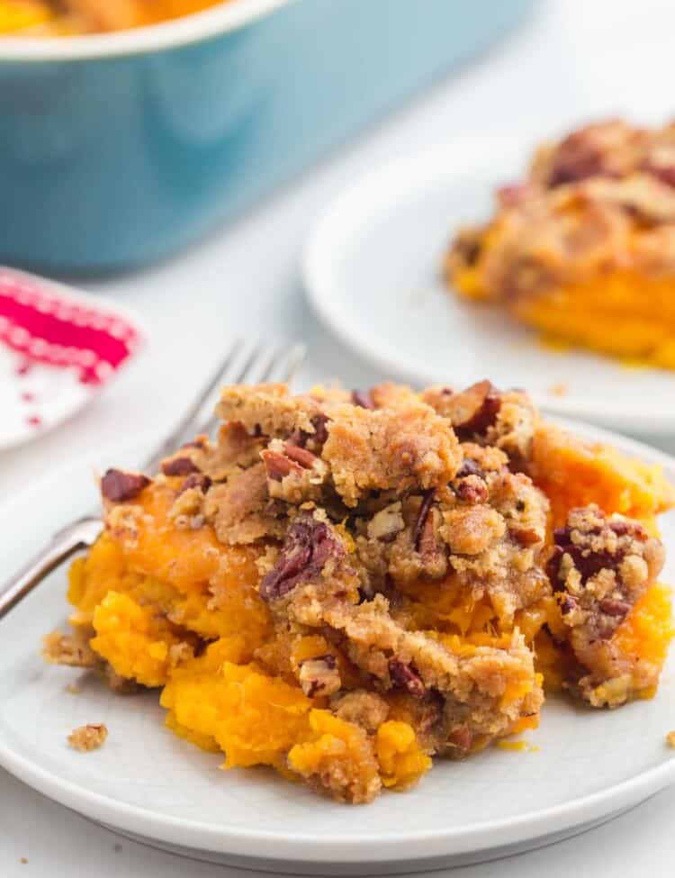 A serving of sweet potato casserole with crunchy pecans on a small plate