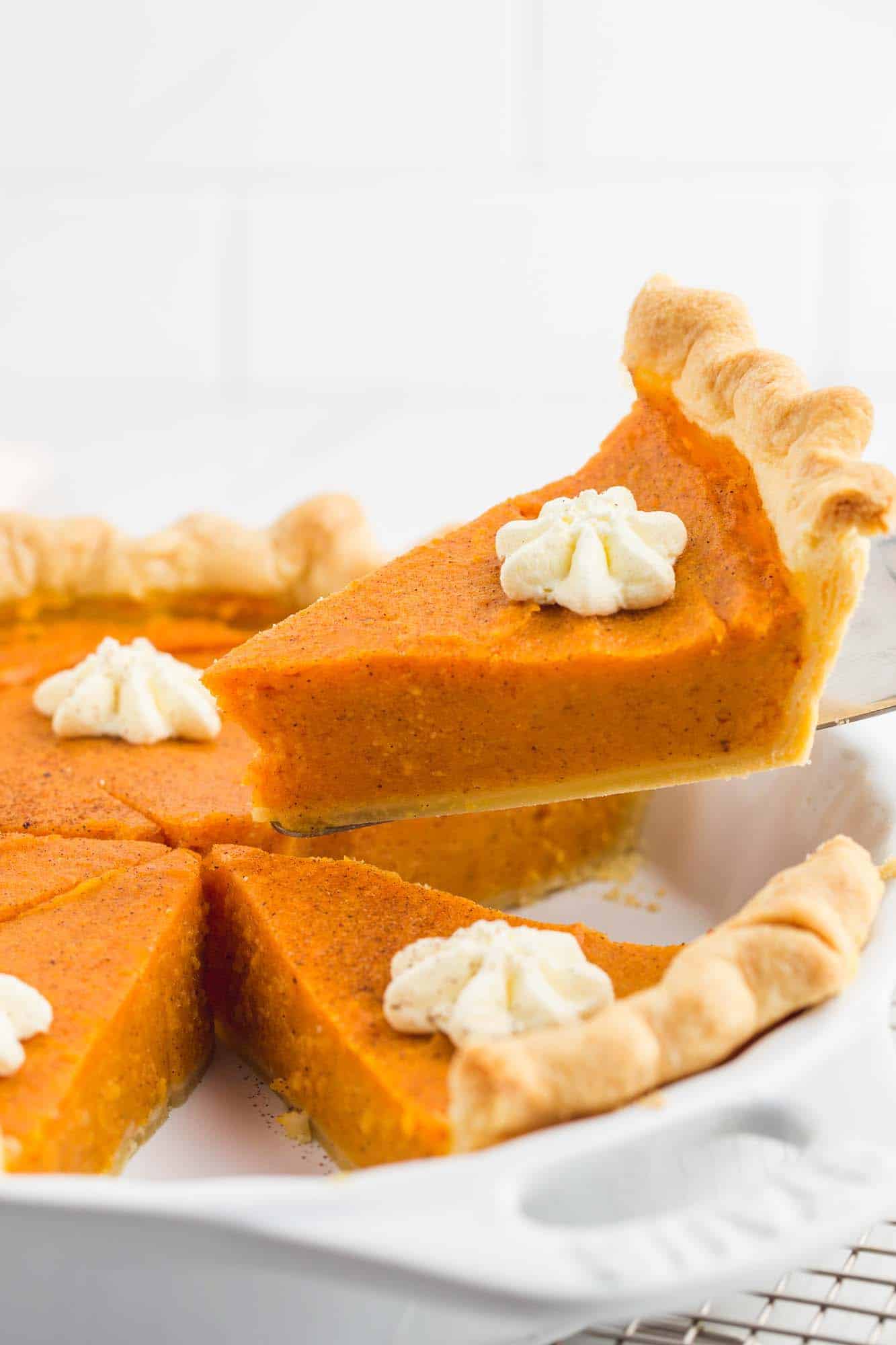 Taking a slice of sweet potato pie from the pie dish