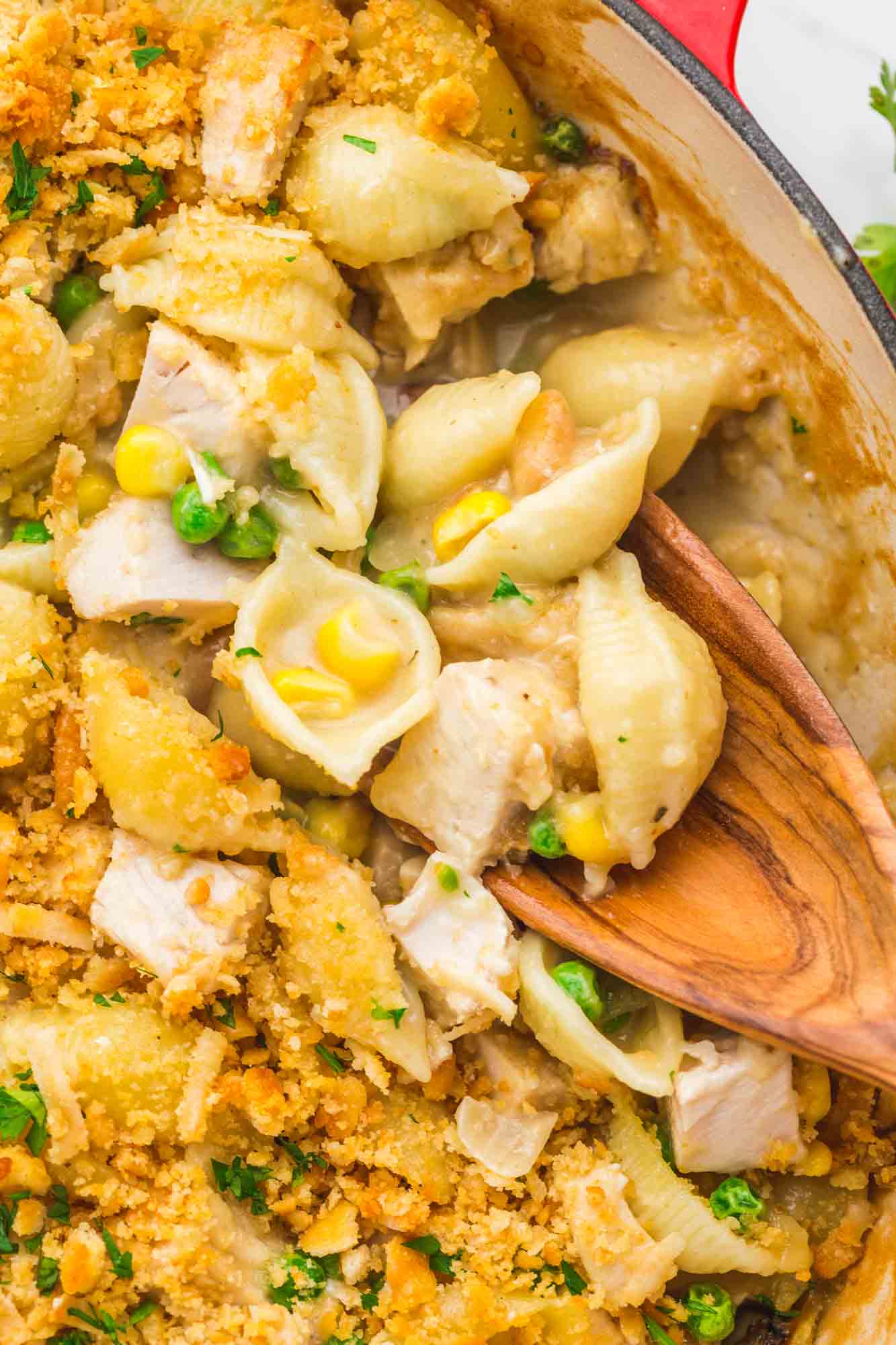 Close up shot of creamy turkey casserole with a wooden spoon