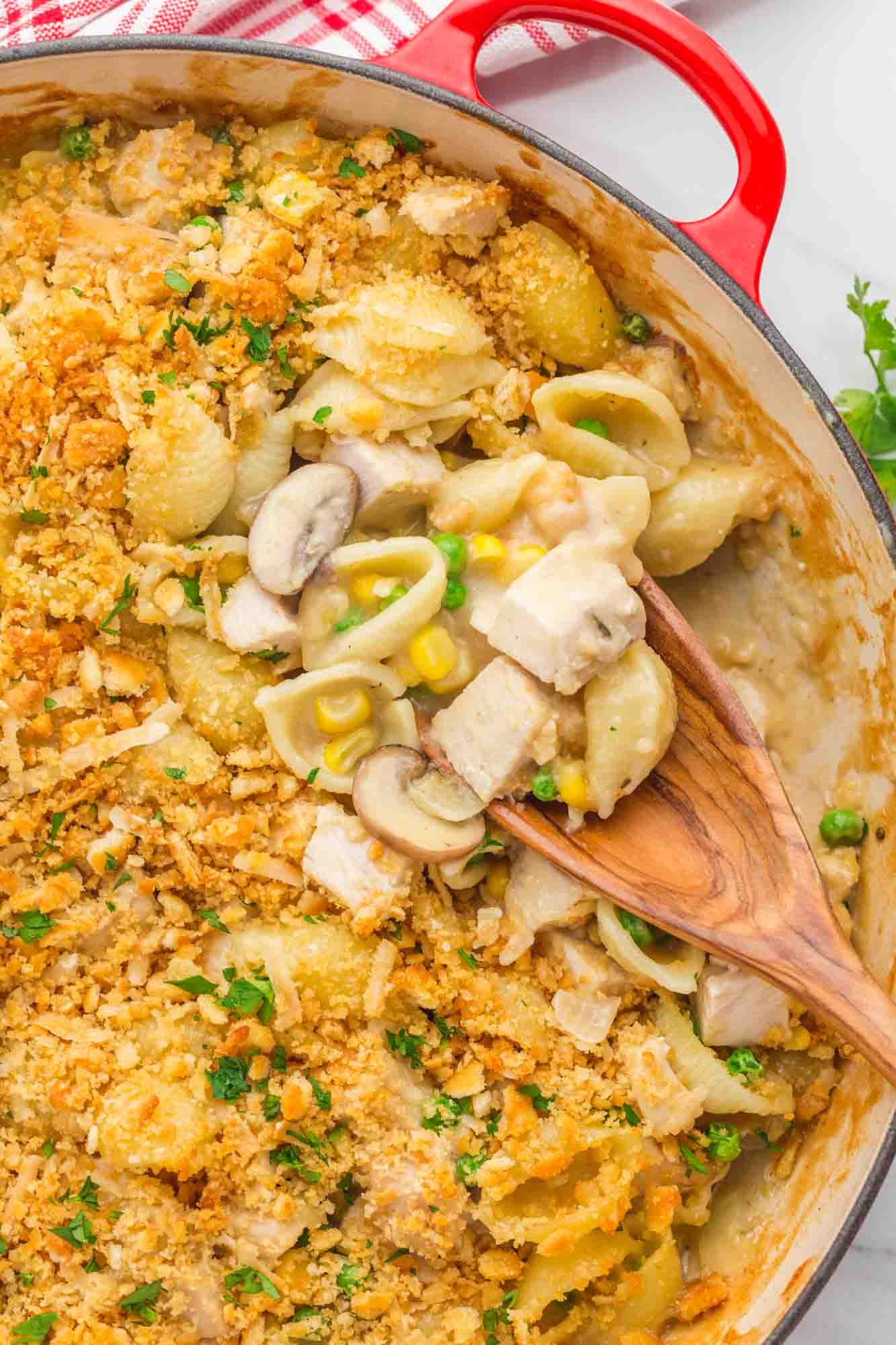 Overhead shot of a turkey casserole in a casserole dish with a wooden spoon