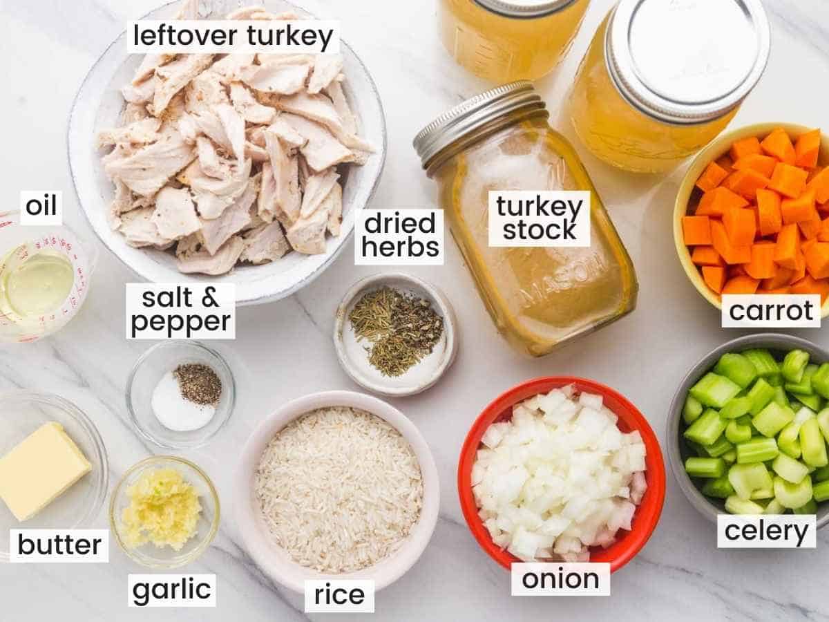 Ingredients needed to make turkey rice soup including leftover turkey, rice, turkey stock, carrot, celery, onion, garlic, butter, oil, dried herbs, salt and pepper.