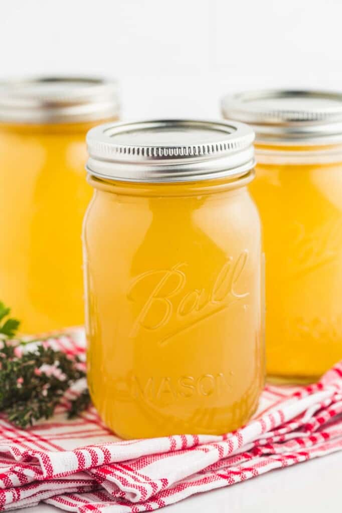 Three cans of clear sunny homemade turkey stock.