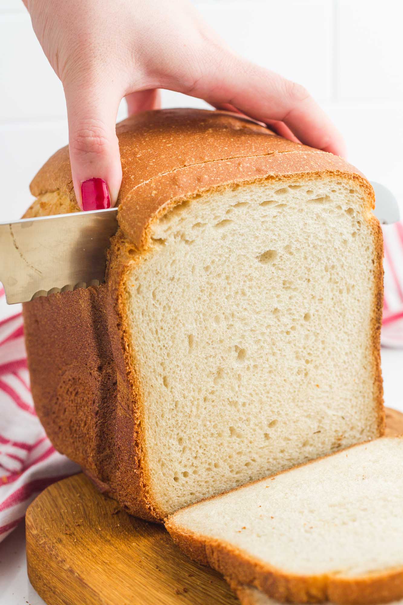 Cutting into a white loaf baked in a bread machine