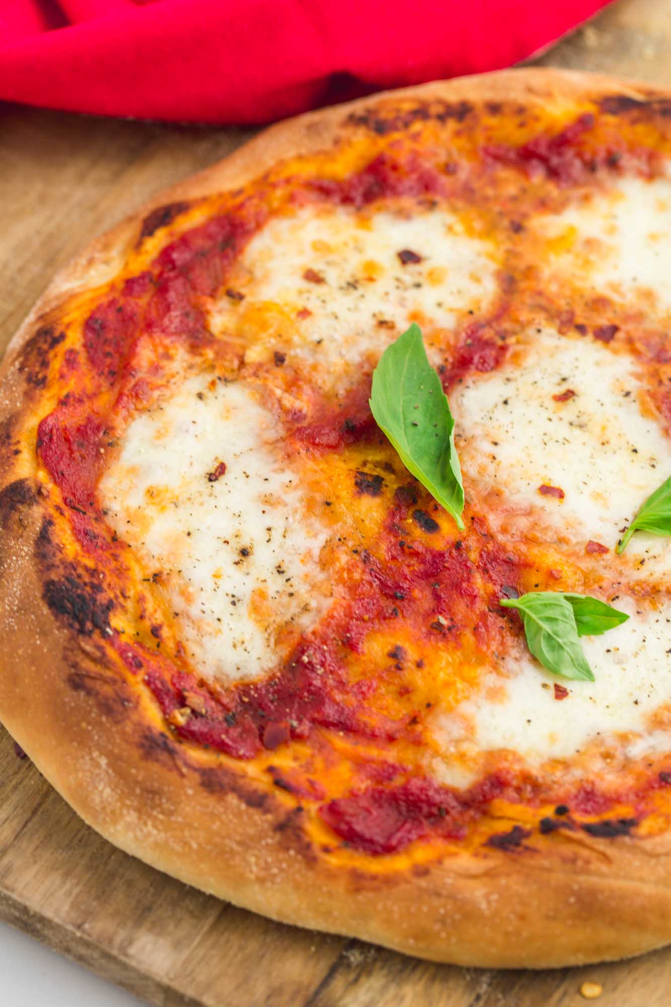 Perfect simple baked pizza, with mozzarella and fresh basil leaves.