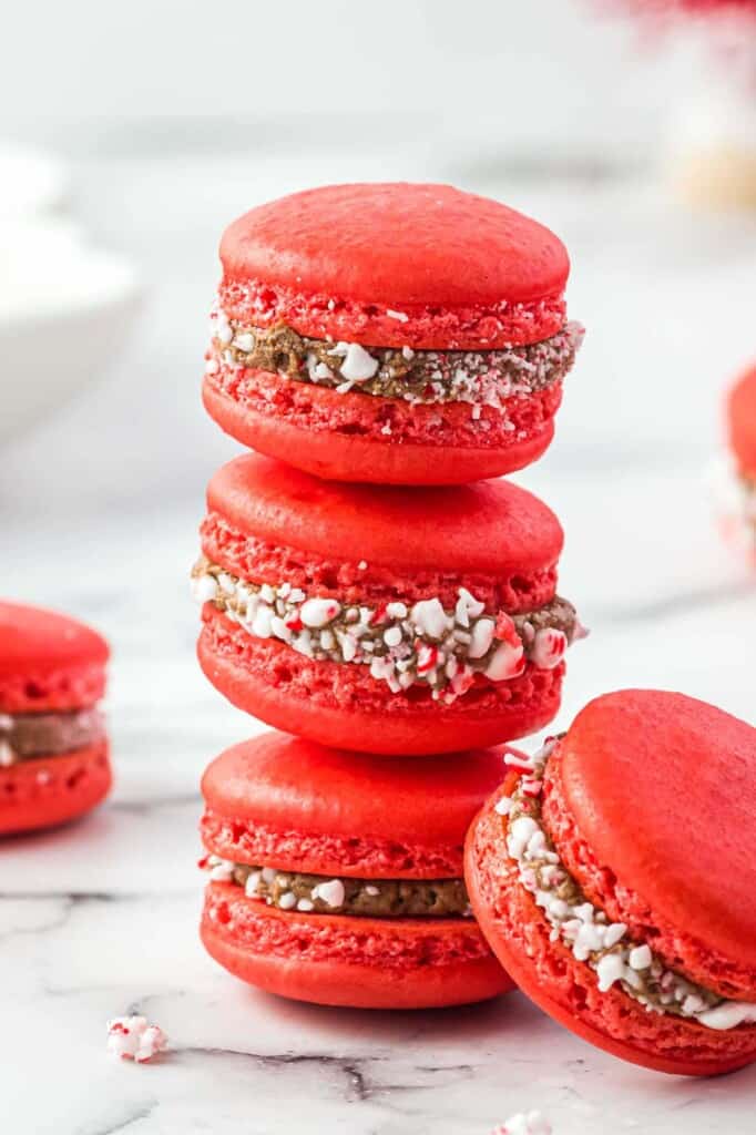 Three peppermint red macarons with chocolate filling stacked