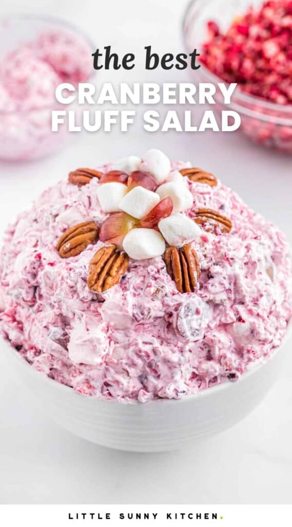Cranberry fluff salad in a white bowl, topped with pecan halves and marshmallows, with overlay text that says "the best cranberry fluff salad"