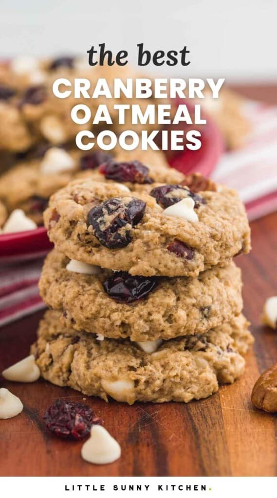 A stack of 3 cranberry oatmeal cookies on a wooden board, with overlay text that says "the best cranberry oatmeal cookies"