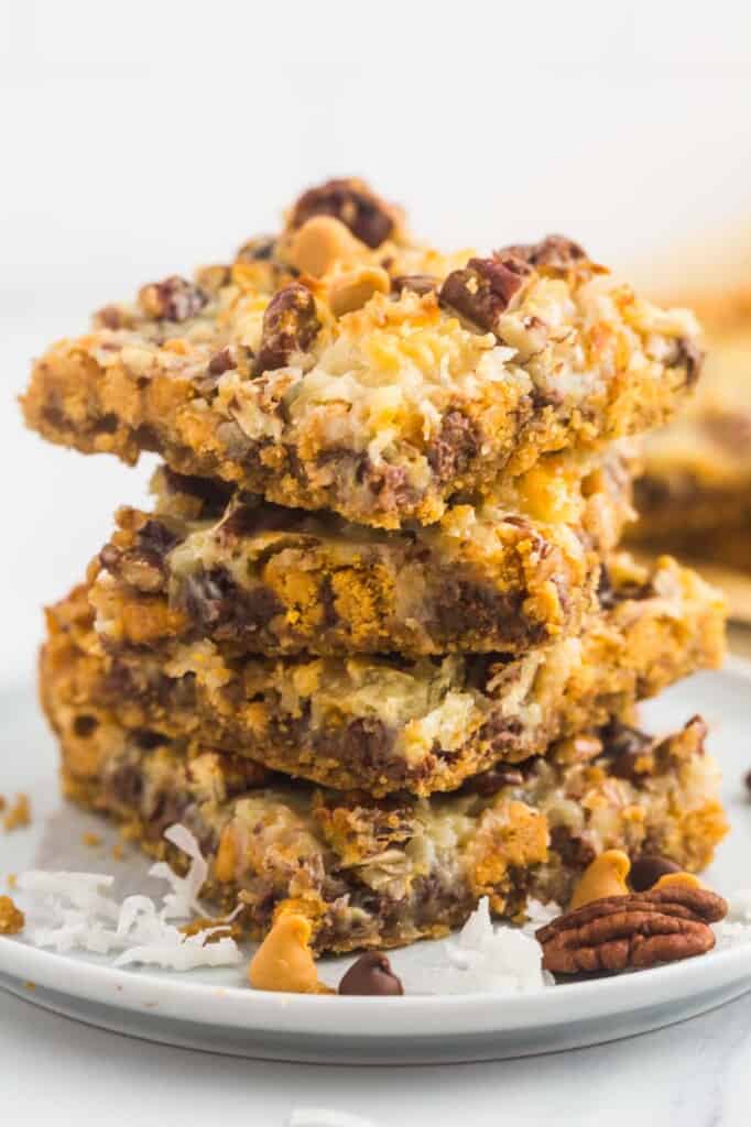 Magic cookie bars stacked on a small white plate