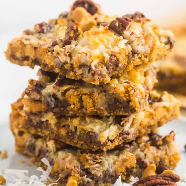 Magic cookie bars stacked on a small white plate