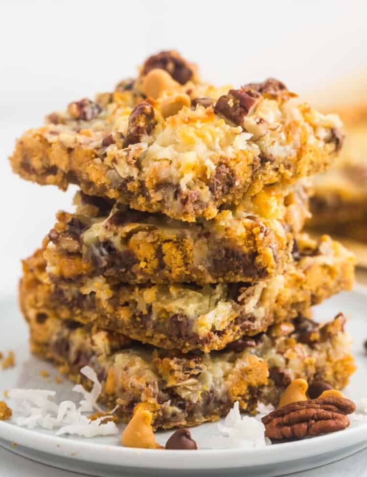 Magic cookie bars stacked on a small white plate
