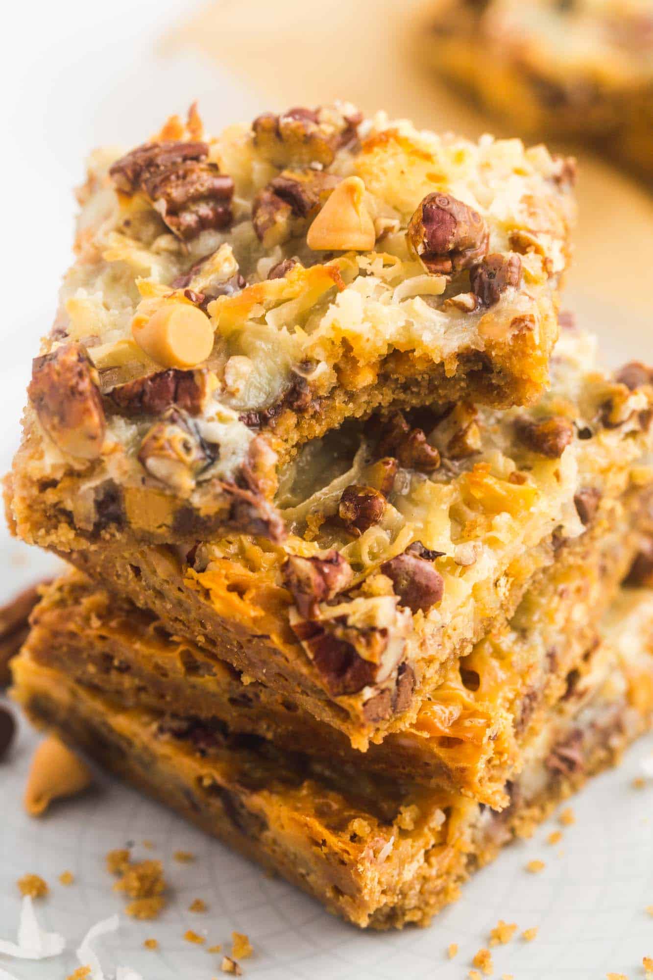Stacked slices of magic bars showing a bite shot