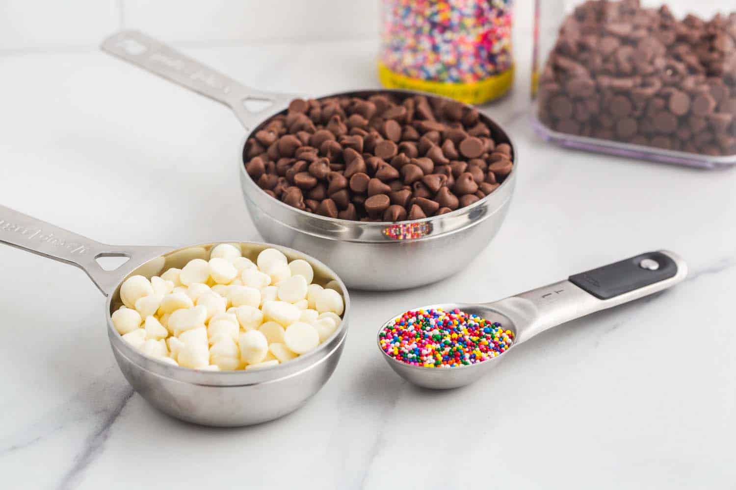 chocolate chips and sprinkles measured out in measuring cups and spoons