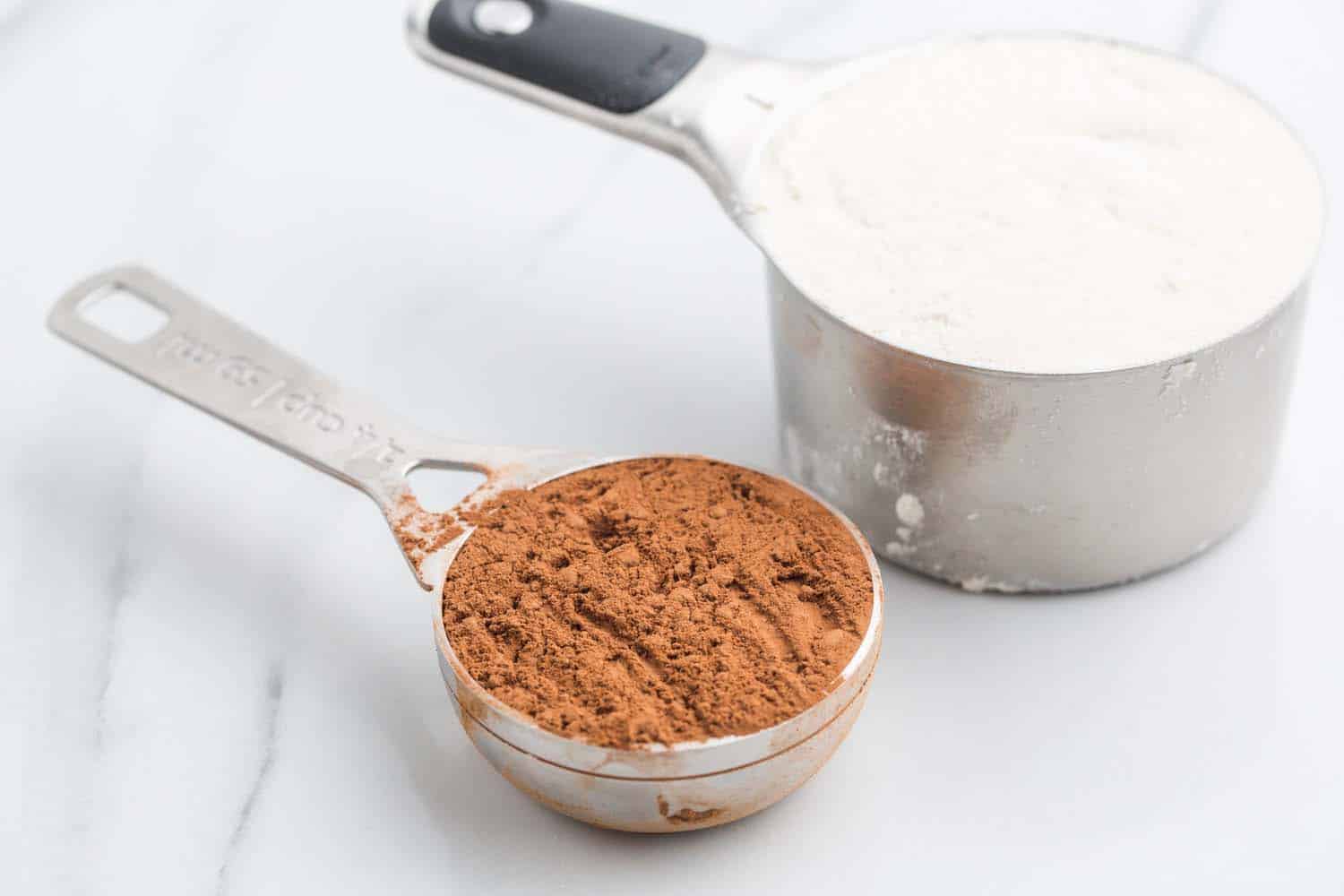cocoa powder and flour measured out in measuring cups