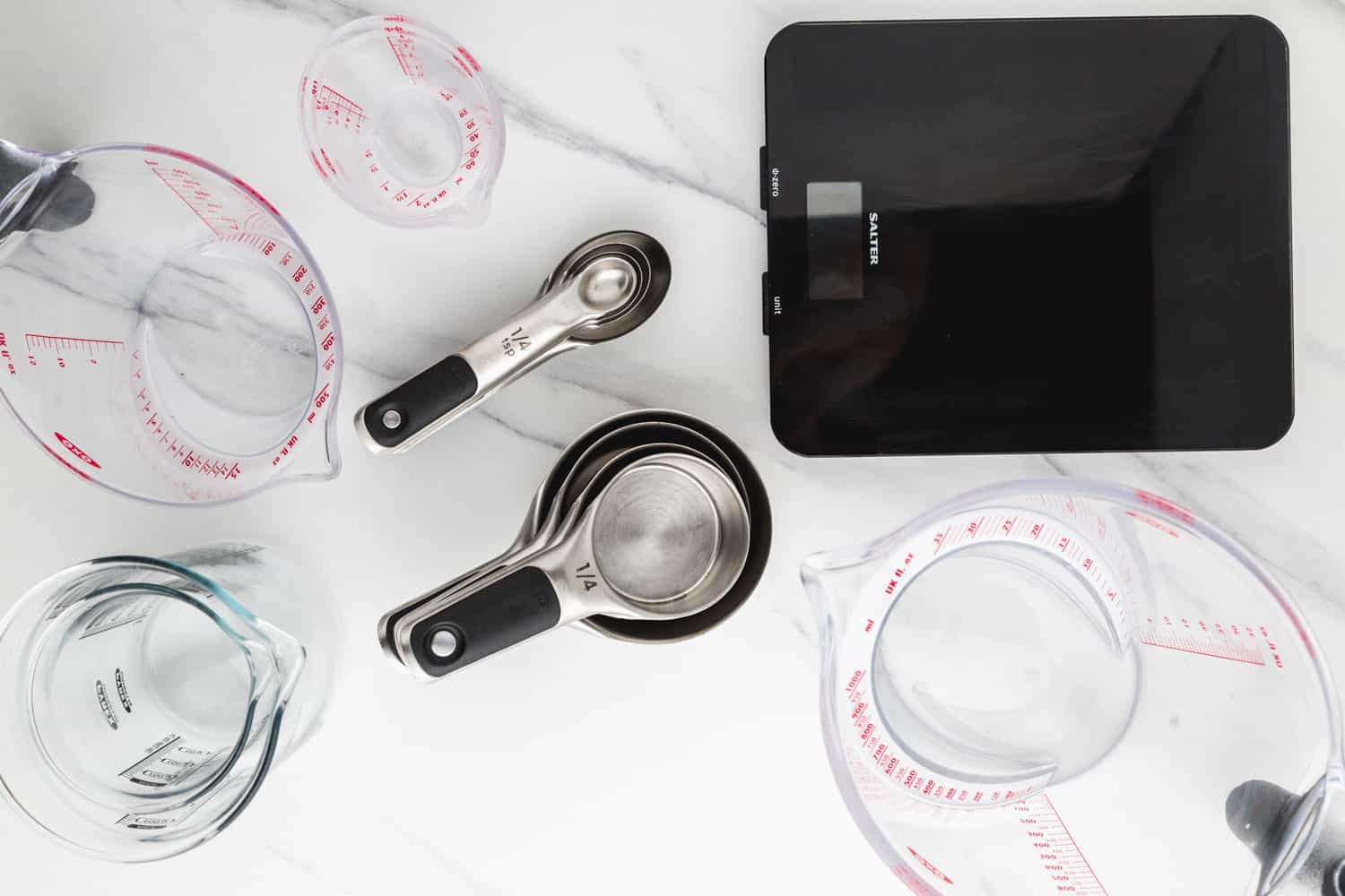 Overhead shot of measuring cups, spoons, and scales.