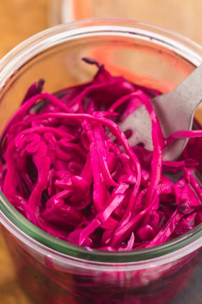 Close up shot of shredded pickled red cabbage in a glass jar