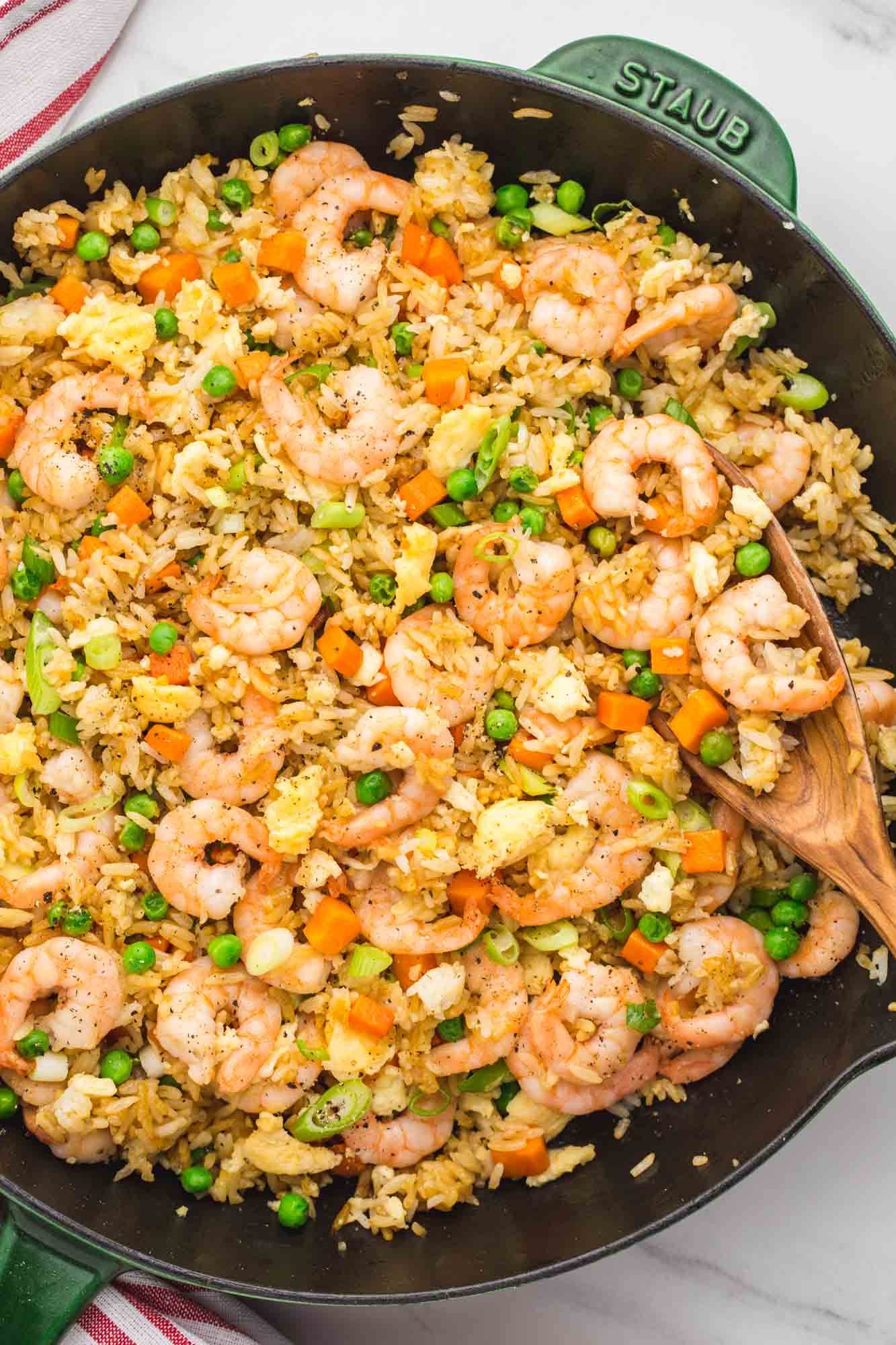 Overhead shot of shrimp fried rice in a green cast iron Staub skillet
