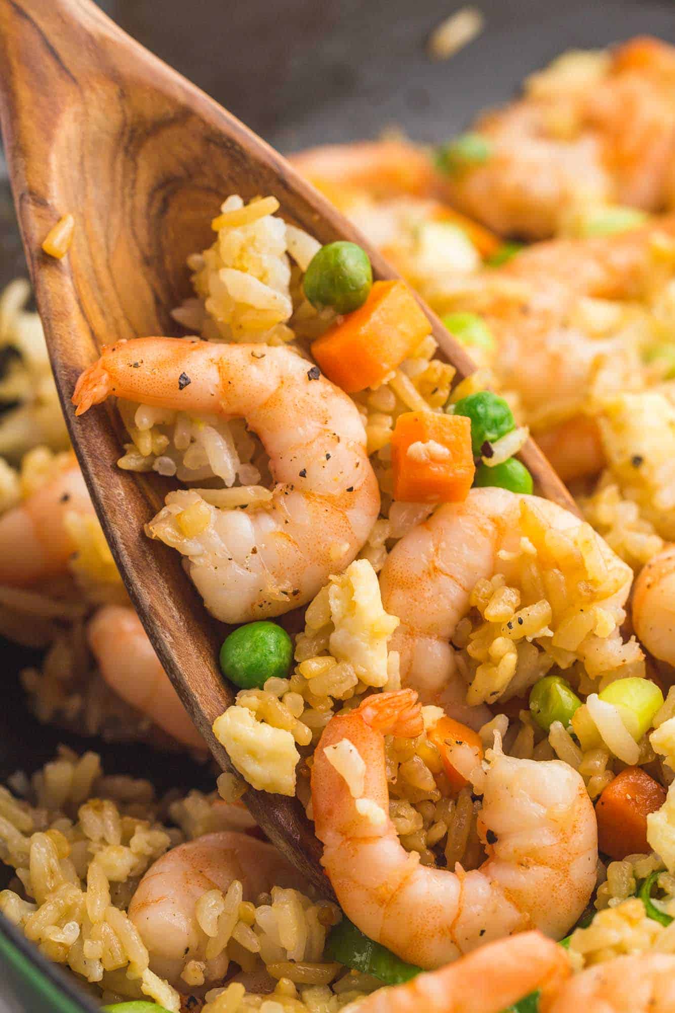 Serving shrimp fried rice with a wooden spoon