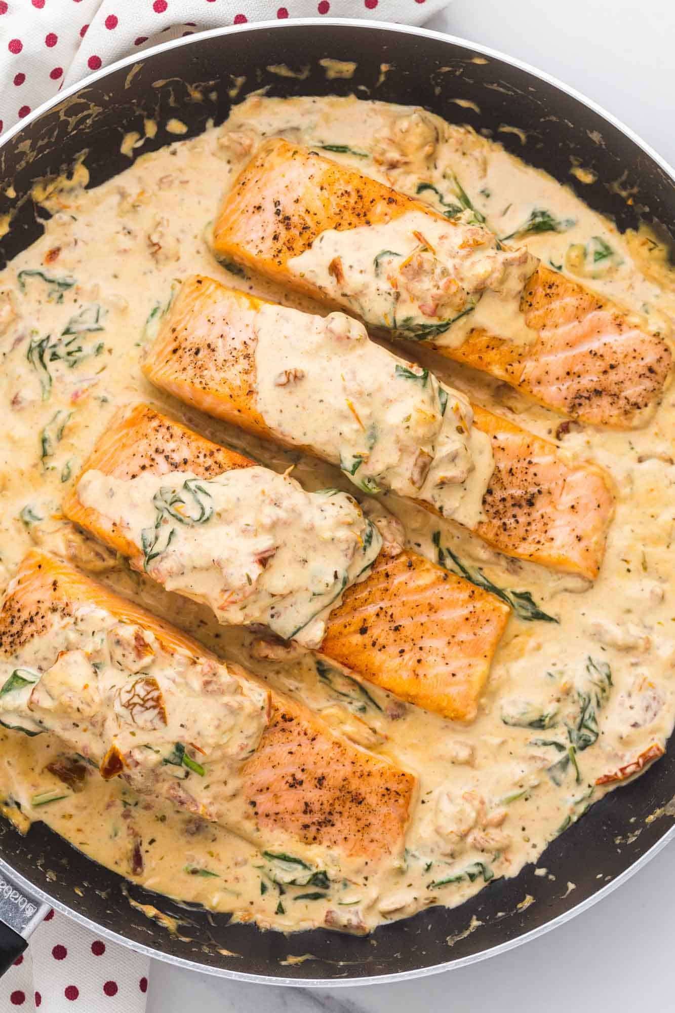 Overhead shot of tuscan salmon in a pan with cream sauce