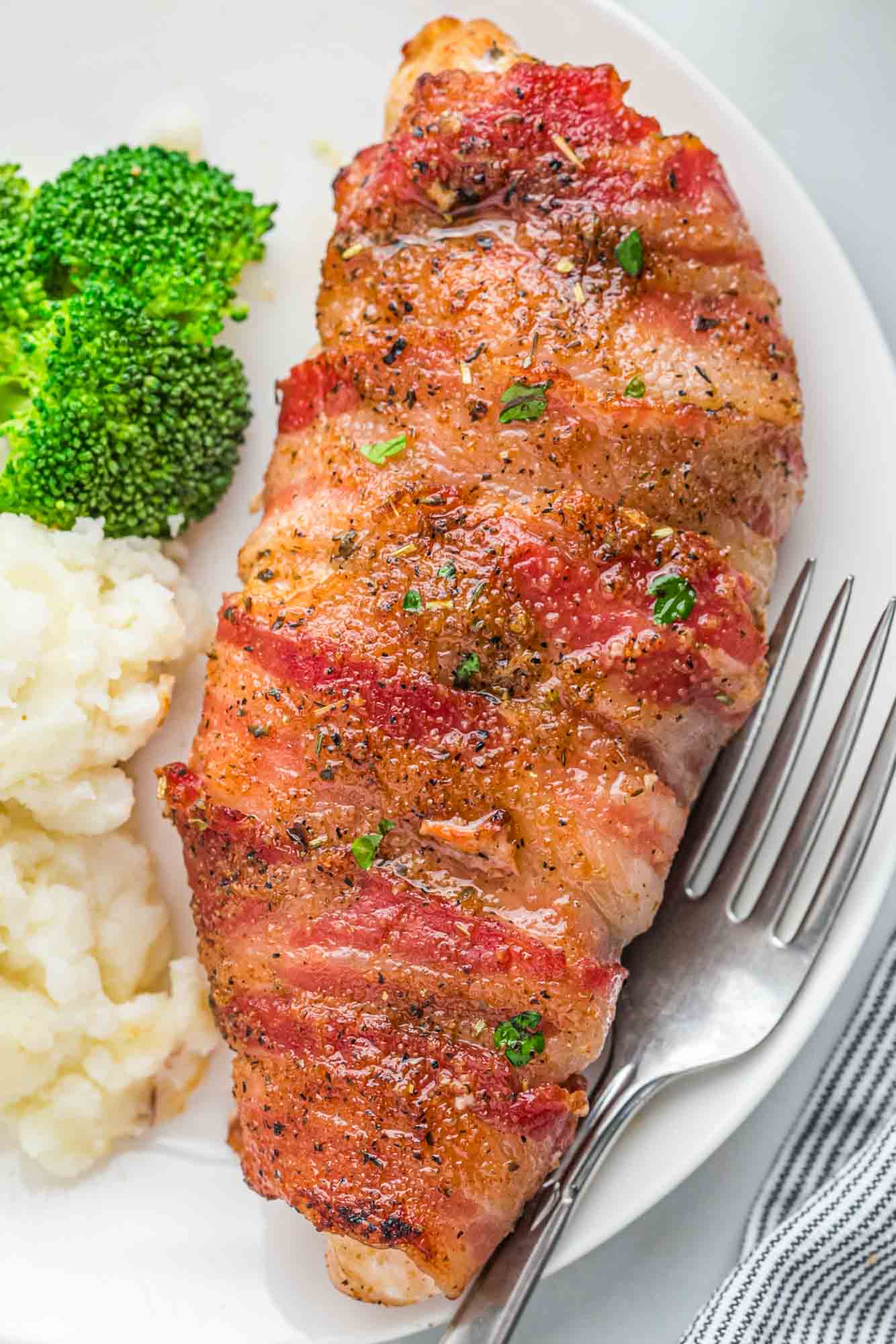 Bacon wrapped chicken breast served with mashed potatoes and steamed broccoli