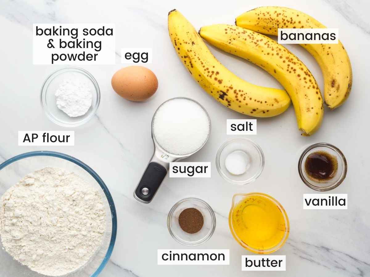 Ingredients needed to make banana muffins including ripe bananas, all purpose flour, sugar, egg, melted butter, cinnamon, vanilla, salt, baking powder and soda.