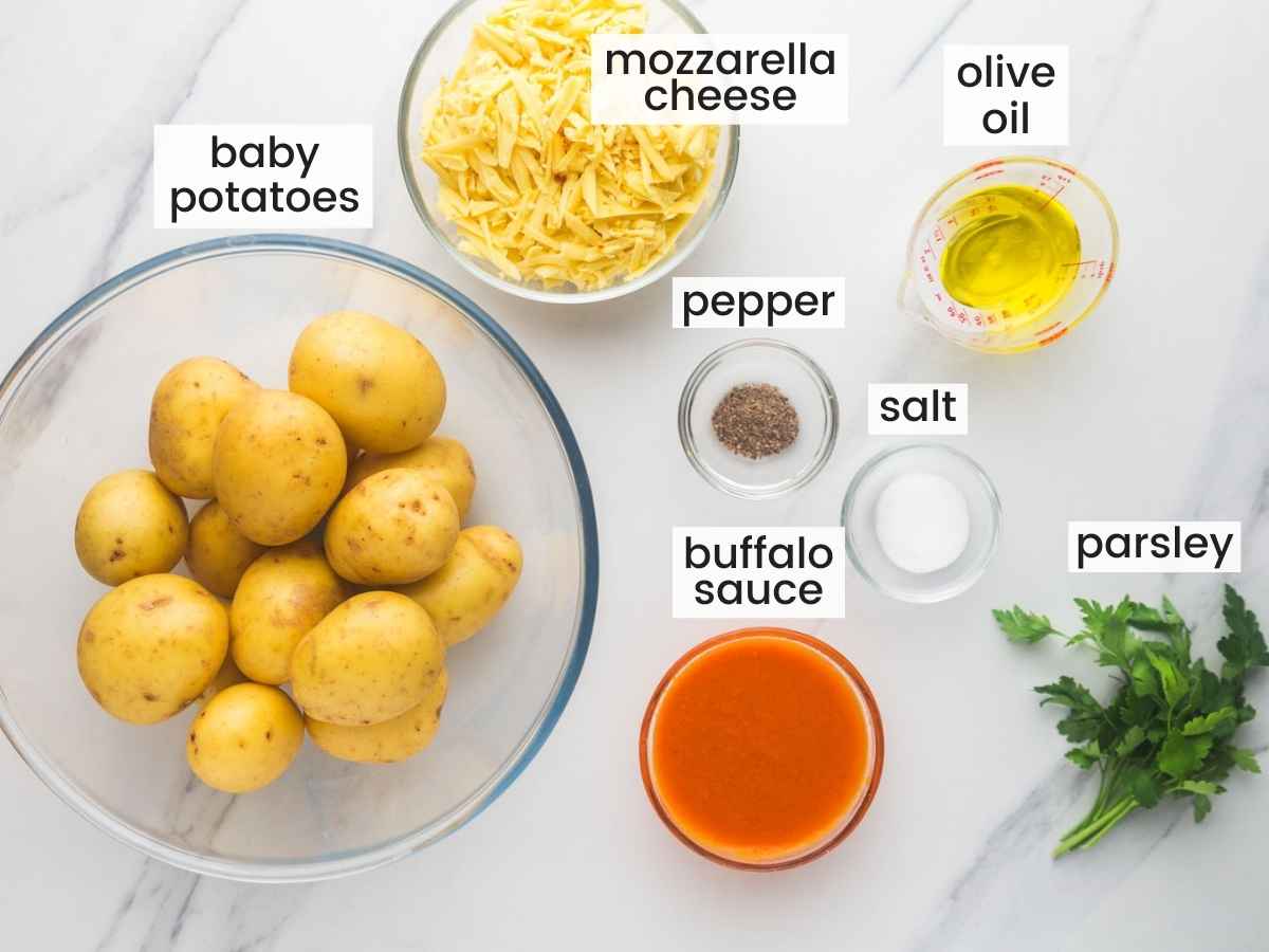 Ingredients needed for making buffalo smashed potatoes including baby potatoes, buffalo sauce, cheese, olive oil, salt, pepper, and parsley.